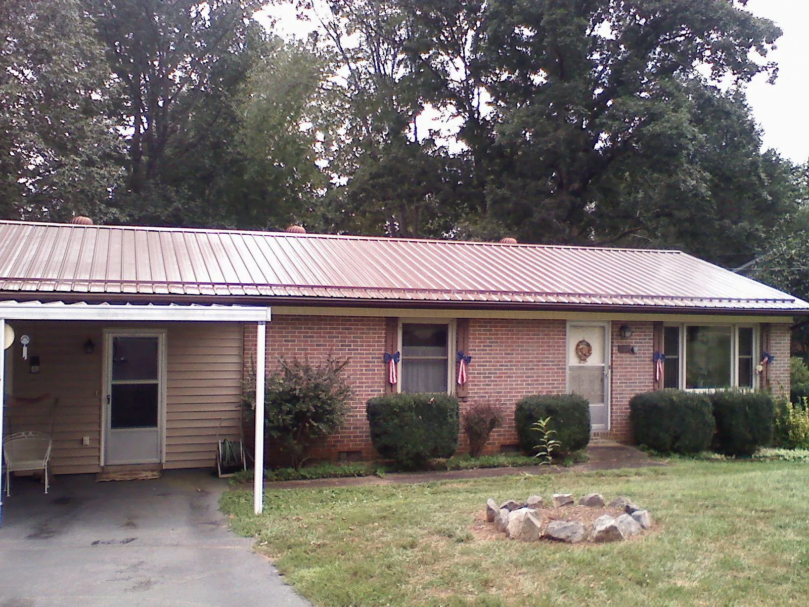 Bronze metal roof and carport on a brick ranch home — Roof Repair work by our crew in Mill Creek